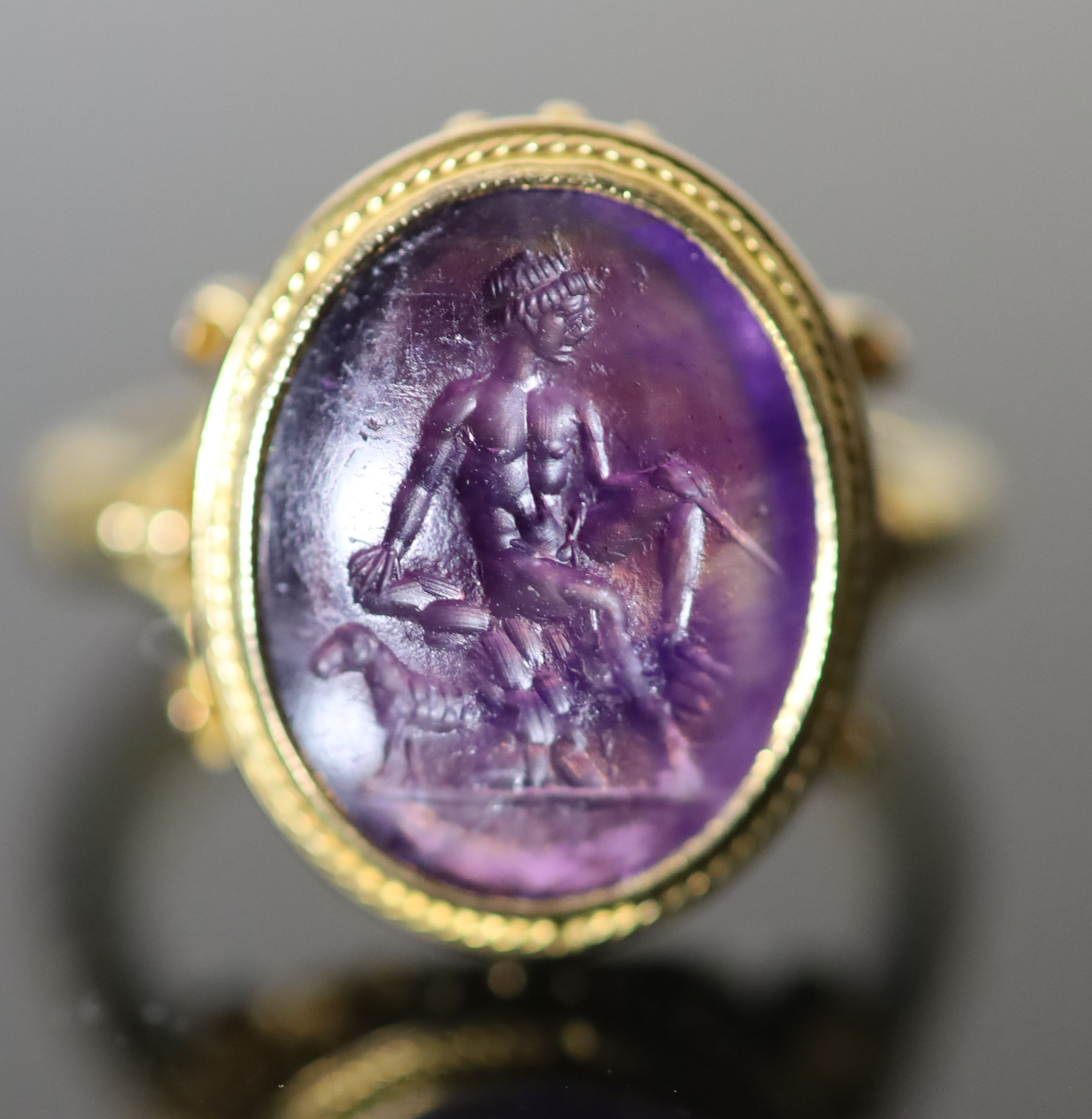 A 19th century style gold ring set with an antique intaglio oval amethyst,